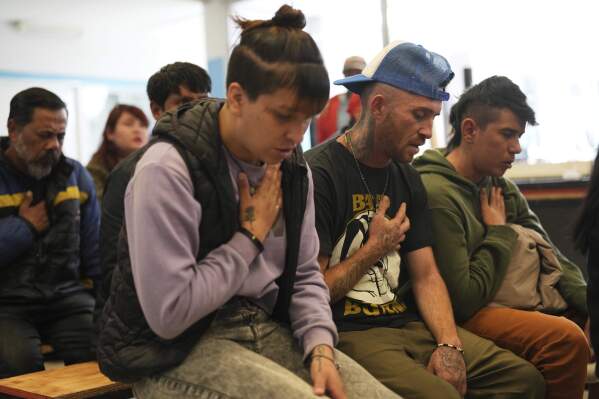 Worshippers pray during a Mass for the late Pope Francis at the Hogares de Cristo community center in the Carlos Mugica neighborhood of Buenos Aires, Argentina, part of a network for drug addicts originally supported by then-Archbishop Jorge Bergoglio, Monday, April 21, 2025. (AP Photo/Rodrigo Abd)